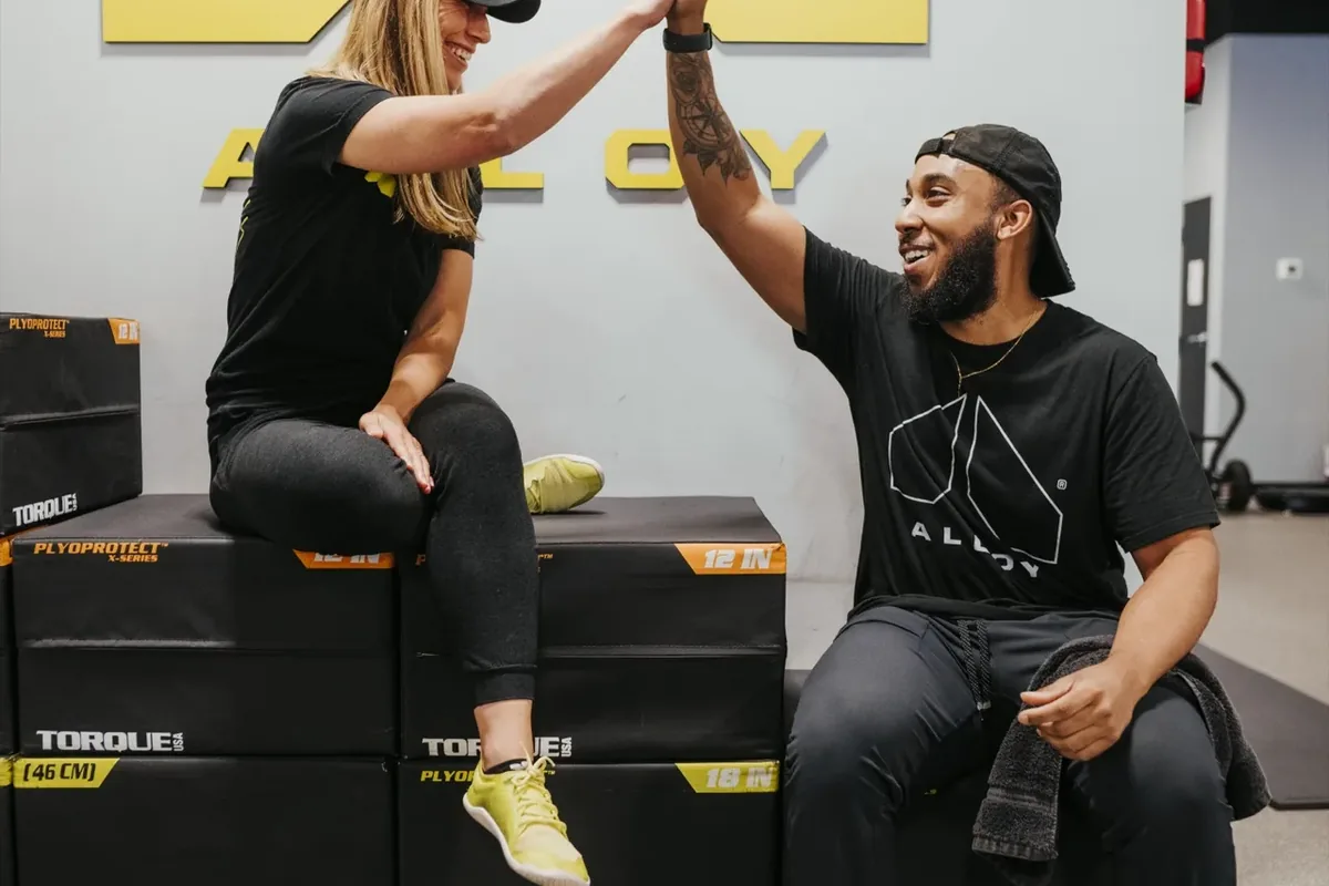 Coach and member high-five after a training session at Alloy Personal Training Ahwatukee Foothills